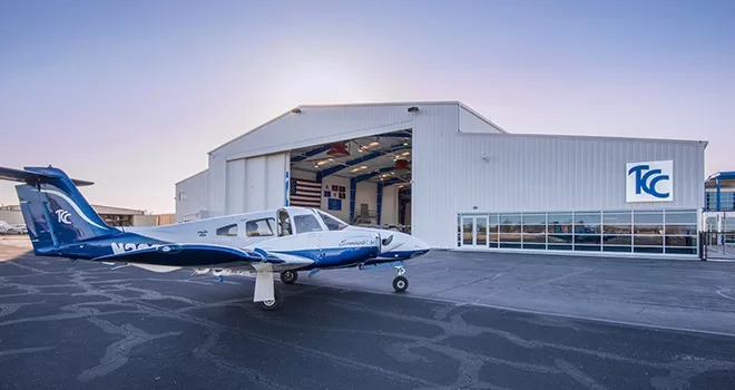 blue and white tcc single engine plane sits parked in front of the 澳门线上博彩 Riverside Aviation Center.