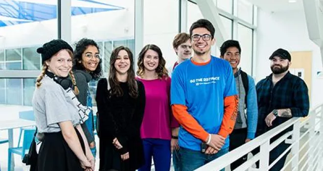 澳门线上博彩 Students pose for group photo on an indoor balcony.