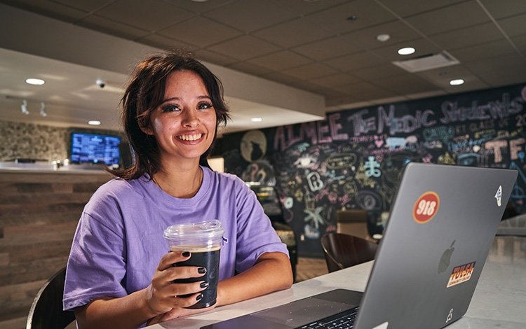 澳门线上博彩 student enjoys an iced coffee at The Perk on 地铁校园.