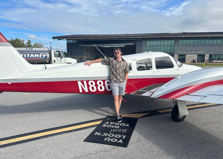 Grant Casebeer stands in front of a plane at Thaden Field House in Bentonville, Arkansas.