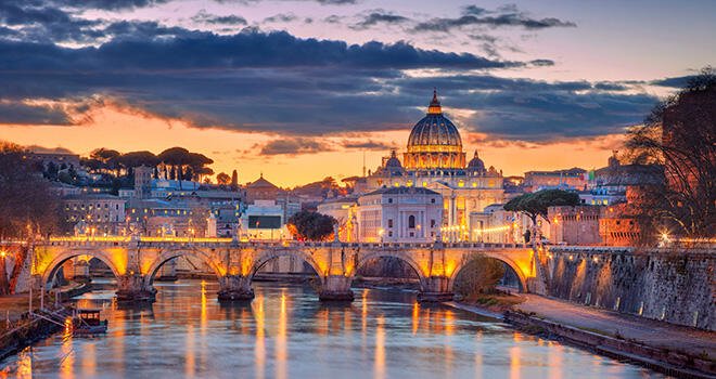 Cityscape of Rome and Vatican City featuring the Saint Peter Basilica during beautiful sunset.